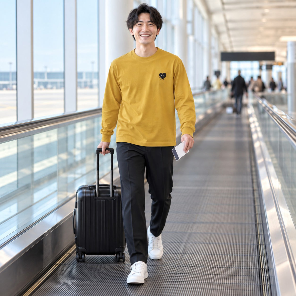 歩くハート「ヨチボウ」ロングTシャツ 空港の動く歩道を歩くヘイジーイエロー